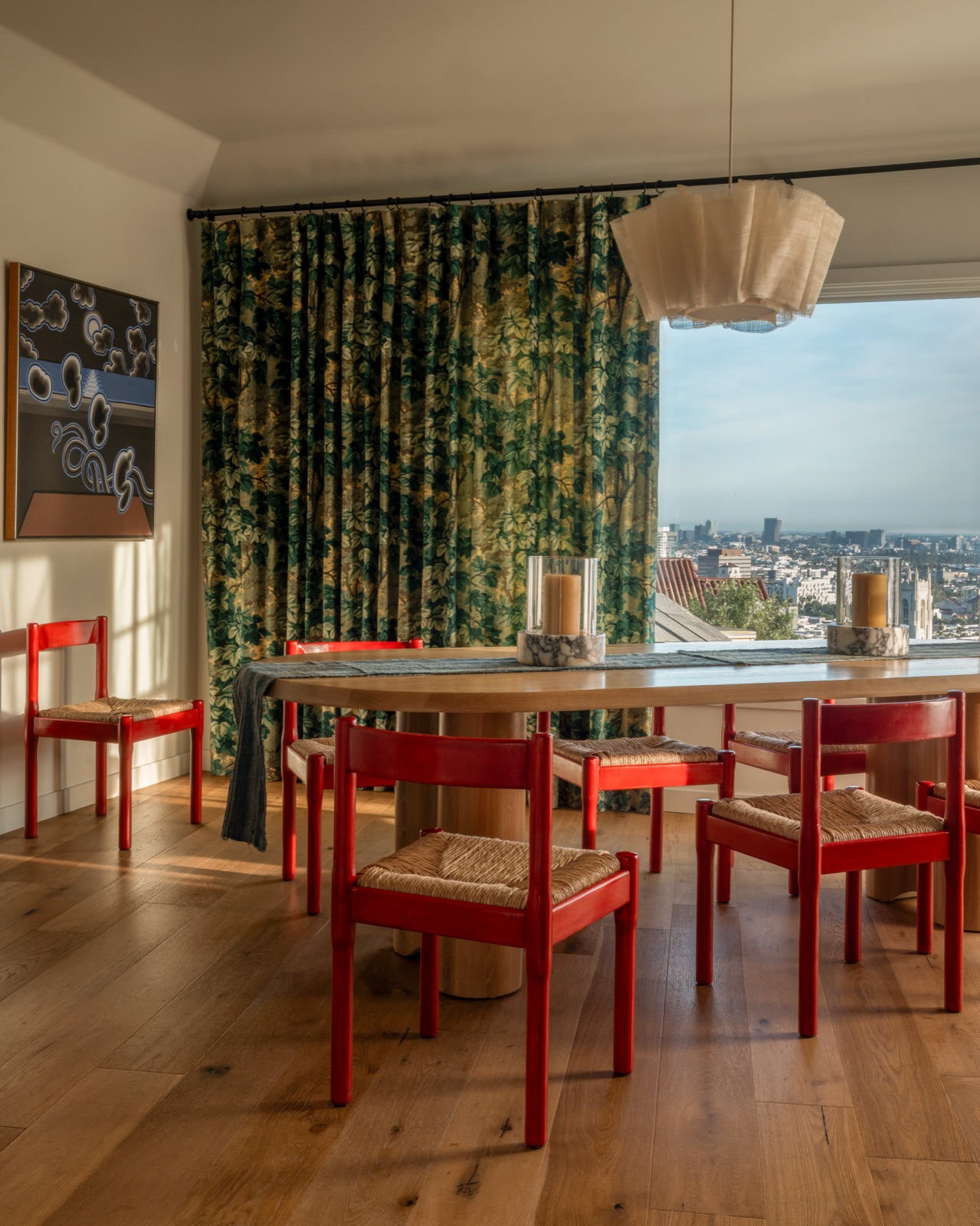 A dining room with red chairs over the Los Angeles skyline, a project by Charlie Barstein